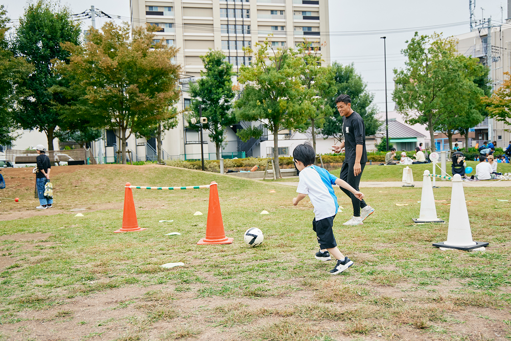 避難用リュックを背負ったドリブル体験　※子供はリュック無し（N.S.T.Pサッカースクール)